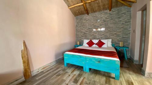 圣佩德罗·德·阿塔卡马Ickota B&B的一间卧室配有蓝色的床和红色枕头