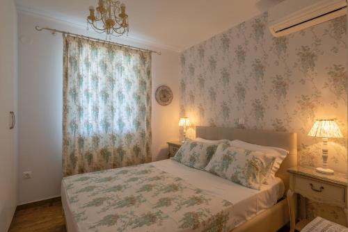 波罗斯MARIOS VILLAS的一间卧室设有床铺和一个带花卉壁纸的窗户。