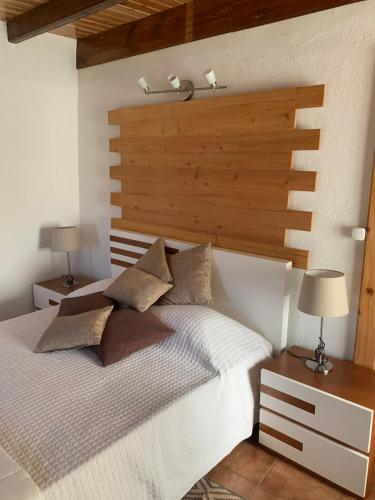 Faja GrandeFajazinha Cottage的卧室配有白色的床和木制床头板