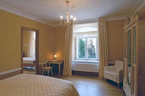 Arbrefontaine名居宅旅馆的一间卧室配有一张床、一个窗口和一张书桌