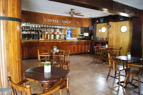 卡波圣卢卡斯Cabo Tortuga Hotel Boutique的一间带桌椅的餐厅和一间咖啡厅