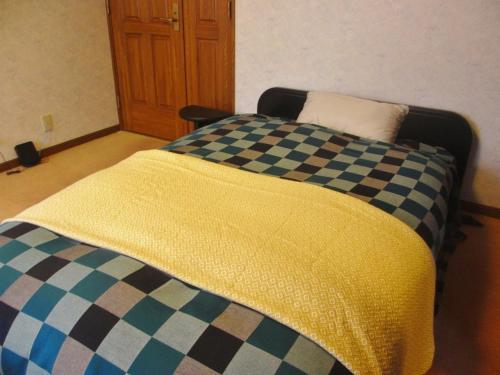 东大阪市Gairoju / Vacation STAY 2561的床上有条条纹毯子