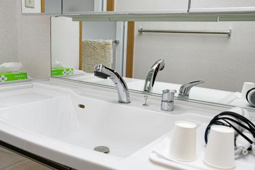 东大阪市Gairoju / Vacation STAY 2561的浴室水槽设有2个水龙头和镜子
