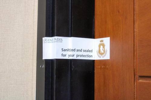 BondowosoGrand Padis Hotel的门上的标志,上面写着,盖上封条,以保护你