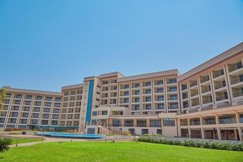 戈马Goma Serena Hotel的一座大型建筑,前面有一个公园