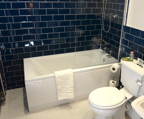比灵斯赫斯特The Kings Head Inn的浴室配有白色浴缸、卫生间和水槽。