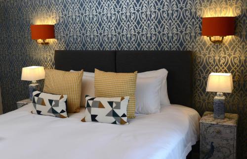 比灵斯赫斯特The Kings Head Inn的一间卧室配有一张带枕头的床和两盏灯。