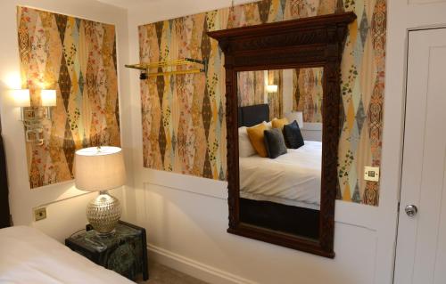 比灵斯赫斯特The Kings Head Inn的卧室配有墙上的镜子