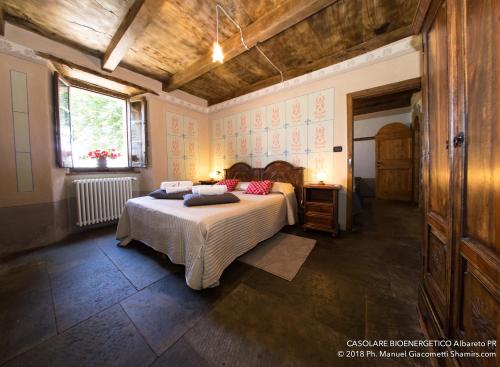 AlbaretoIl Casolare Bioenergetico的一间卧室配有带枕头的床