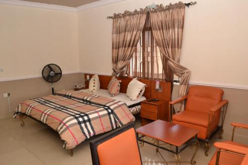 Suru LereRoom in Lodge - Aquatic Suites Lounge的卧室配有床、椅子和窗户。