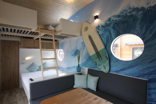 库克斯港Tiny Wave Tiny House auf dem Campingplatz Strandgut的墙上有冲浪板壁画的房间