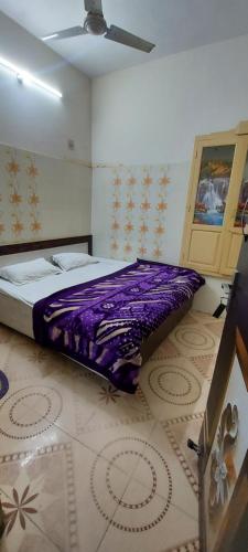 阿姆利则MJ Chawla Homestay golden temple 400 m walking distance的地板上紫色毯子的房间里一张床位