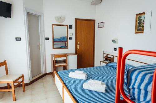 里米尼蒙特卡洛酒店的一间卧室配有一张床,上面有两条毛巾