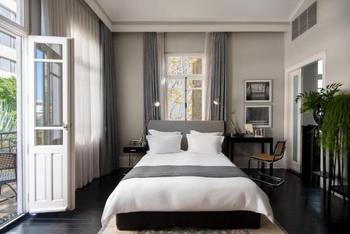 特拉维夫蒙蒂菲奥里酒店的一间卧室设有一张大床和一个窗户。