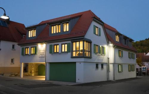 exNicrum Wein . Genuss . Hotel的白色绿色的房屋,有红色的屋顶