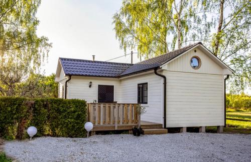 VeberödBjörkeslund的前面有长凳的小白色房子