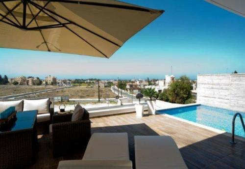 帕福斯Leonidas VILLA的客厅设有游泳池和庭院。