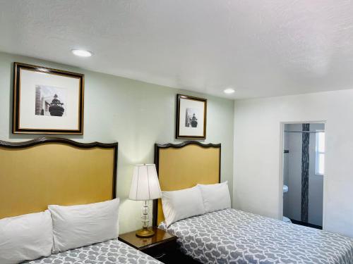 萨拉索塔Siesta Inn Sarasota - Indian Beach的酒店客房,设有两张床和一盏灯