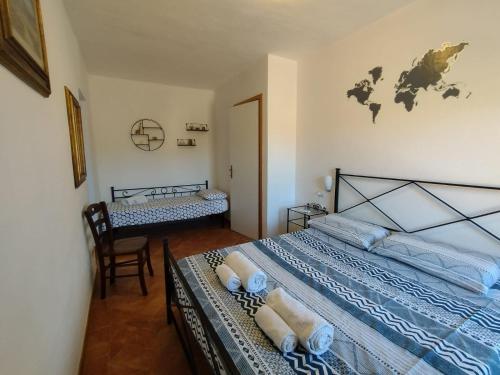 费拉约港Bed & Bike Casa dei Papi的一间卧室配有两张单人床和一把椅子