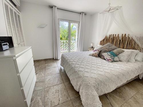 东方湾Princess Coco, Beachfront, Pool, Orient Bay, ultra fast Wifi的一间卧室设有一张床和一个大窗户