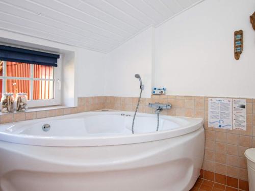 孔斯马克Holiday home Rømø LI的带窗户的浴室内的白色浴缸