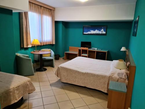 韦尔切利莫多酒店的酒店客房设有两张床、一张桌子和一张桌子。