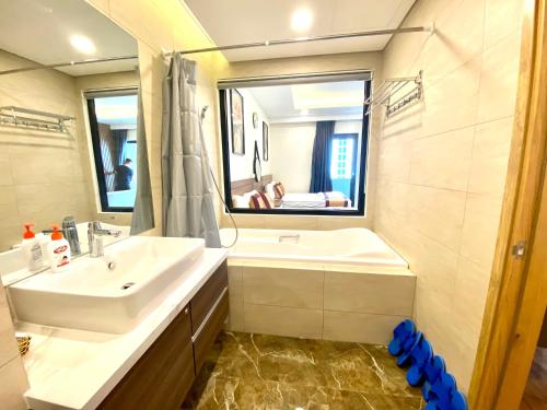 归仁FLC SEA TOWER Quy Nhon- Kizz House的一间带水槽、浴缸和镜子的浴室