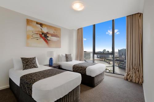墨尔本Jade Resorts Melbourne的酒店客房设有两张床和大窗户。