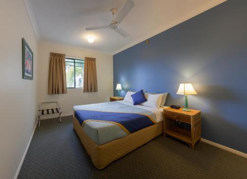 凯恩斯凯恩斯格罗夫纳酒店的一间卧室配有一张蓝色墙壁的床