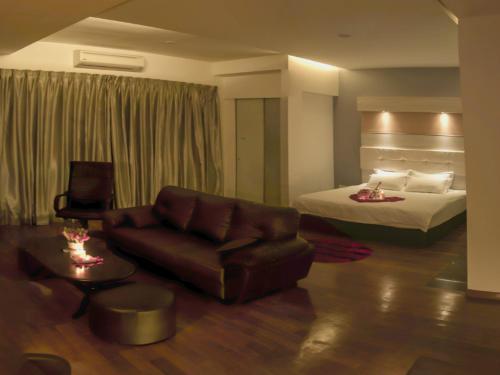 士姑来先锋酒店的酒店客房配有一张床和一张皮沙发