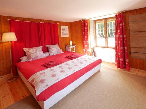 MarnozDomaine de Bellevue Gîte du Mont Poupet的一间卧室配有一张带红色窗帘的床和一扇窗户