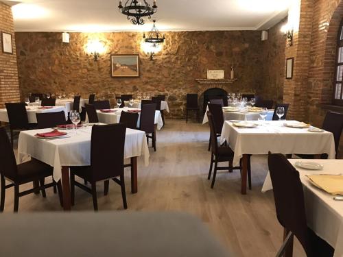 夸科斯德尤斯特亚巴迪亚德乌斯特乡村酒店 的餐厅设有白色的桌椅和壁炉