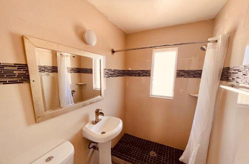 萨拉索塔Siesta Inn Sarasota - Indian Beach的一间带水槽、卫生间和镜子的浴室