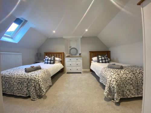 彭布罗克郡The Cottage的阁楼卧室设有两张床和窗户。