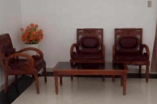 RantauprapatGreen House Syariah Mitra RedDoorz的三把椅子和一张桌子
