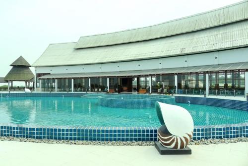 丹老拉古娜明珠度假酒店的一座大型游泳池,其建筑背景为: