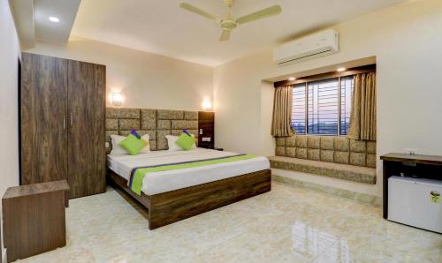 加尔各答Hotel Bandhan Residency的一间卧室配有一张床和一台电视