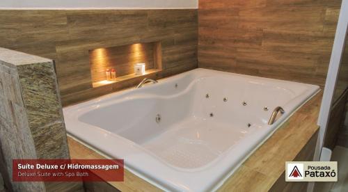 乌巴图巴帕塔克斯奥旅馆的浴室设有大型白色浴缸,配有木饰