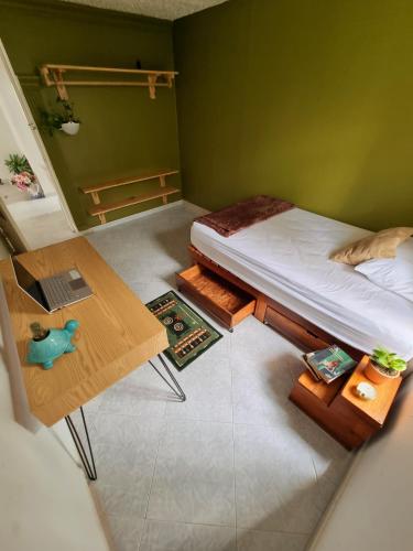 布卡拉曼加Tatami Hostel的小房间设有一张床和一张桌子