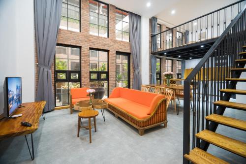 岘港Flexi Hotel & Apartment的公寓设有橙色的沙发和楼梯。