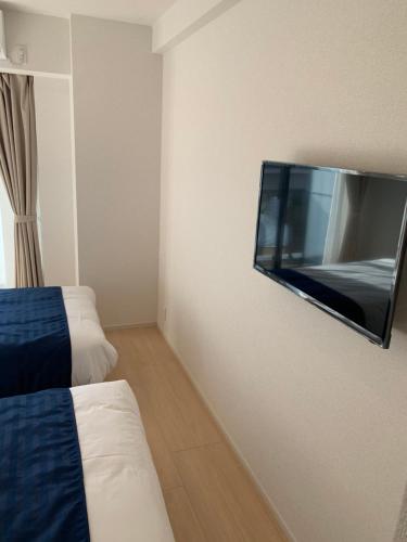 东京Hotel Emir的酒店客房的墙上配有平面电视