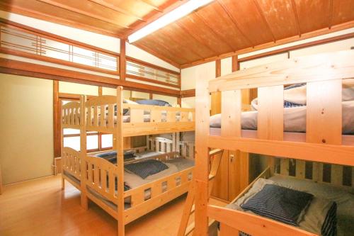 松山Guesthouse Omoya的房屋内带4张双层床的房间
