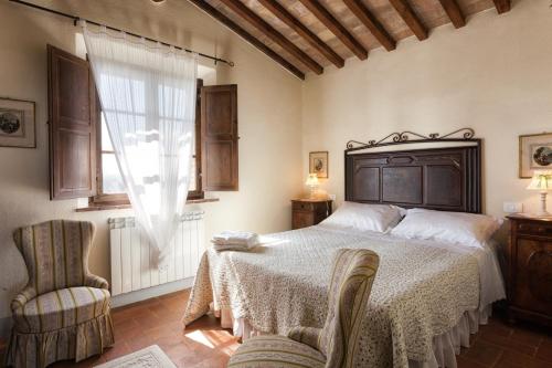蒙塔尔奇诺Agriturismo MONSOLE - Montalcino的卧室配有床、椅子和窗户。