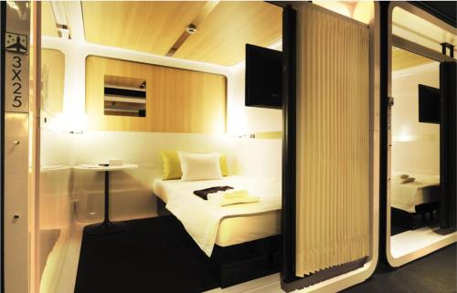 KashōjiFirst Cabin Kansai Airport的酒店客房,配有床和镜子
