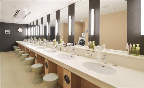 泉佐野First Cabin Kansai Airport的一间带一排盥洗盆和卫生间的大浴室