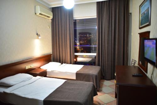 阿拉尼亚特米兹酒店的酒店客房设有两张床和窗户。