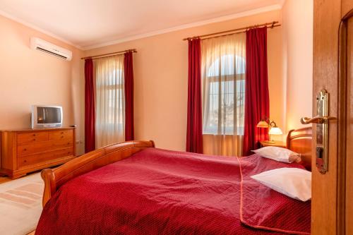 达内什Hotel Denis的一间卧室配有一张带红色毯子的床