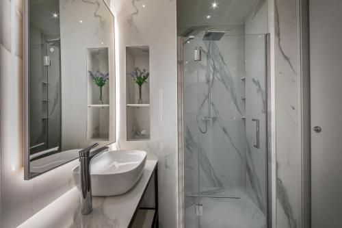尼科西亚Maralia Hotel的白色的浴室设有水槽和淋浴。