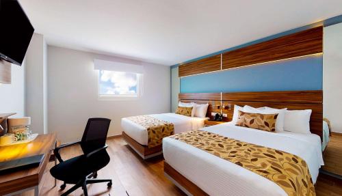 克雷塔罗Sleep Inn Queretaro的酒店客房配有两张床和一张书桌