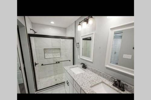 新奥尔良10 mins from Downtown New Orleans *a must see *的白色的浴室设有2个盥洗盆和淋浴。